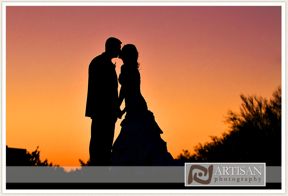 bride and groom silhouette kiss with the sunset in the background