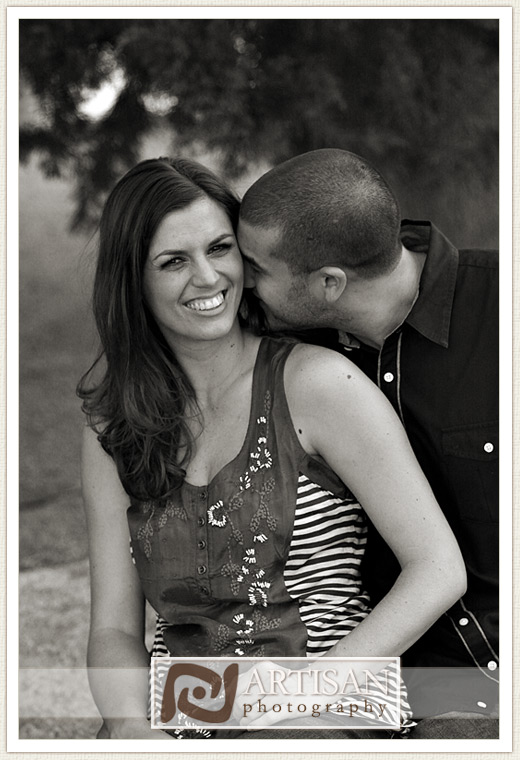 engagement photos at the park in Gilbert couple with sports jerseys kissing from the back