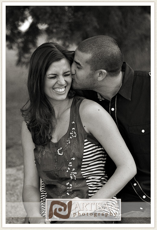 engagement photos at the park in Gilbert couple with sports jerseys kissing from the back