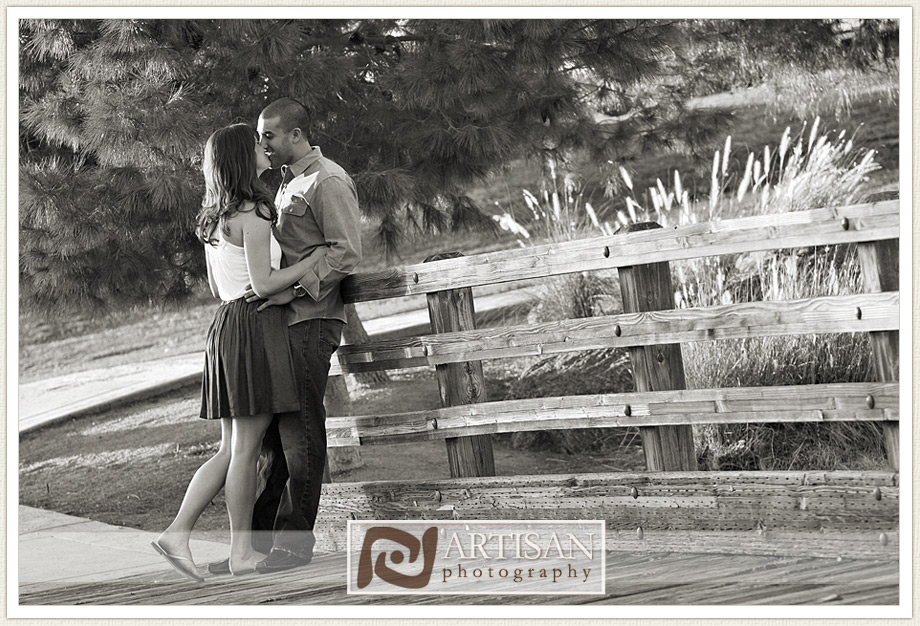 engagement photos at the park in Gilbert couple with sports jerseys kissing from the back