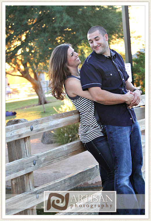 engagement photos at the park in Gilbert couple with sports jerseys kissing from the back