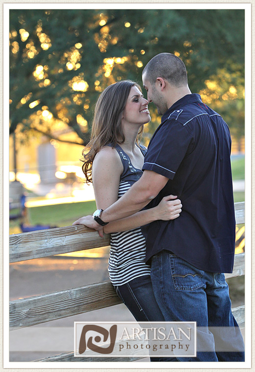 engagement photos at the park in Gilbert couple with sports jerseys kissing from the back