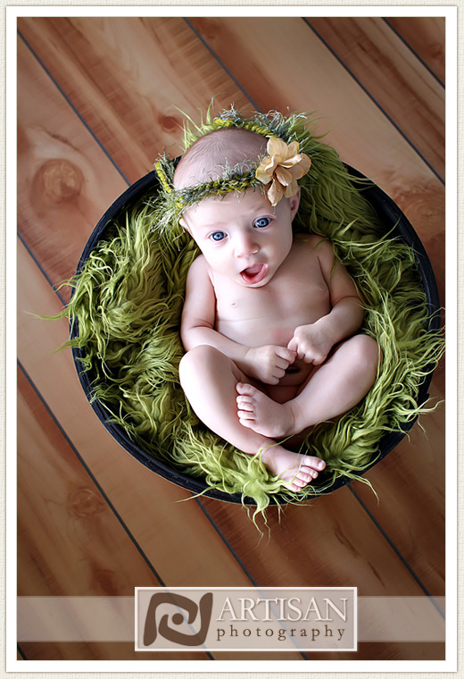 Newborn baby photos in basket with green rug and blue eyes