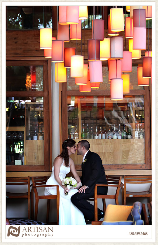 Bride and groom at Friesky Resort on the bar with orange luminarias in the ceiling
