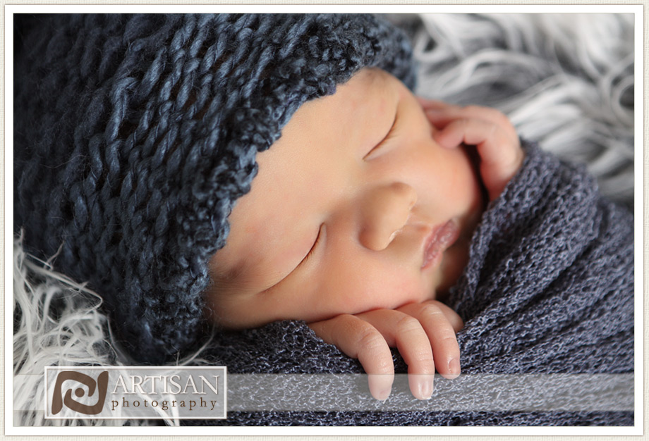 baby wrapped in blue knit fabric close up photo