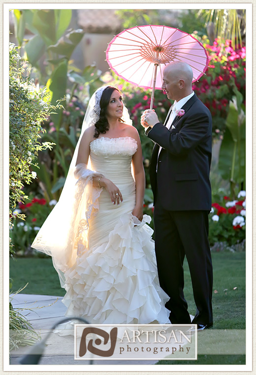 Royal Palms Wedding image of bride and groom walking with pink parasol 