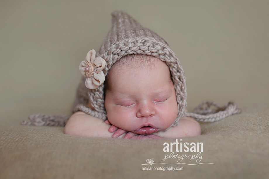 baby girl laying on blanket with flower hat close up shot