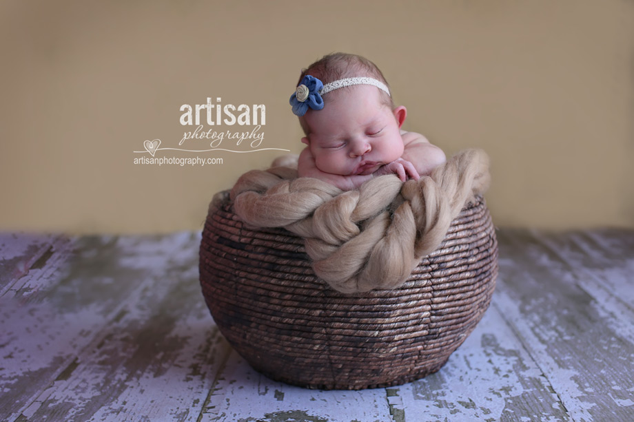 baby girl in wood woven basket with flower headband