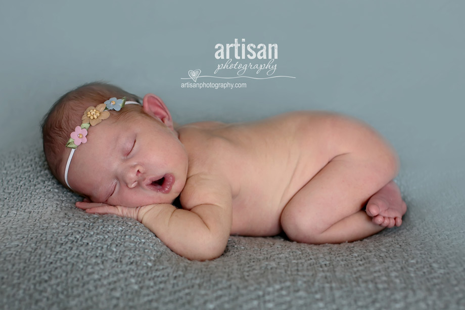 baby girl laying on blanket with flower headband