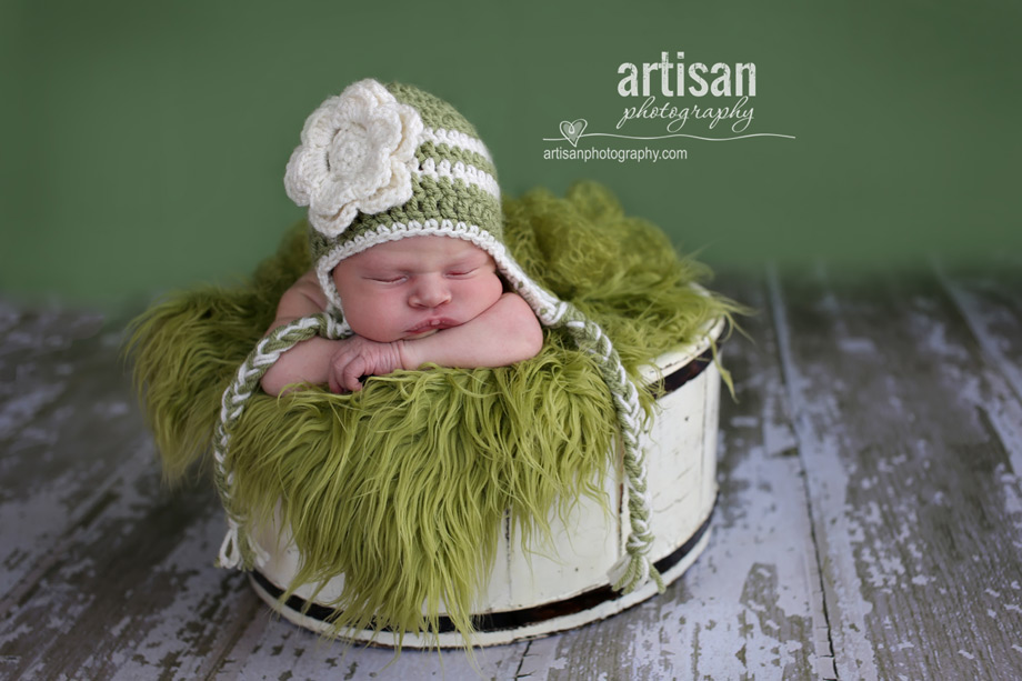 baby girl in vintage white basket with green fur