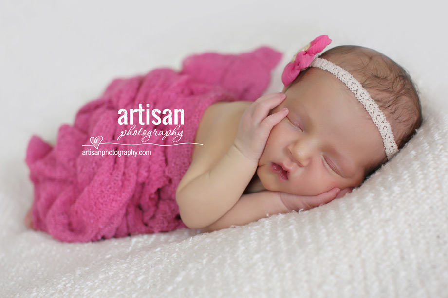 newborn baby girl photo at our Carlsbad studio in California with pink wrapp and pink flower