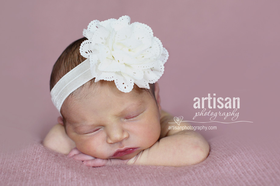 newborn baby girl photo at our Carlsbad studio in California with a big white flower band