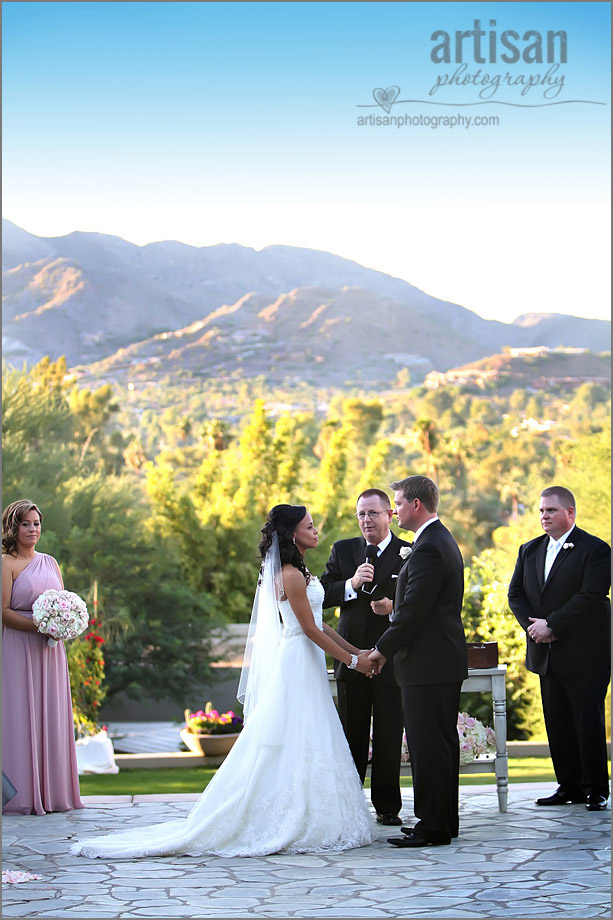 Bride and Groom holding hands during the ceremony with beautiful Arizona mountains in the background