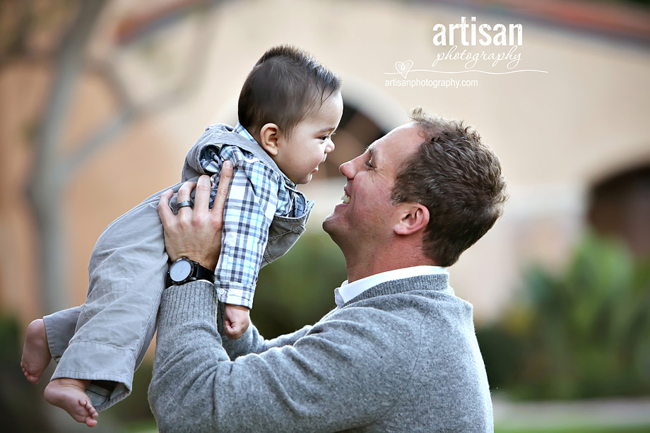 Father looking at baby holding him up 