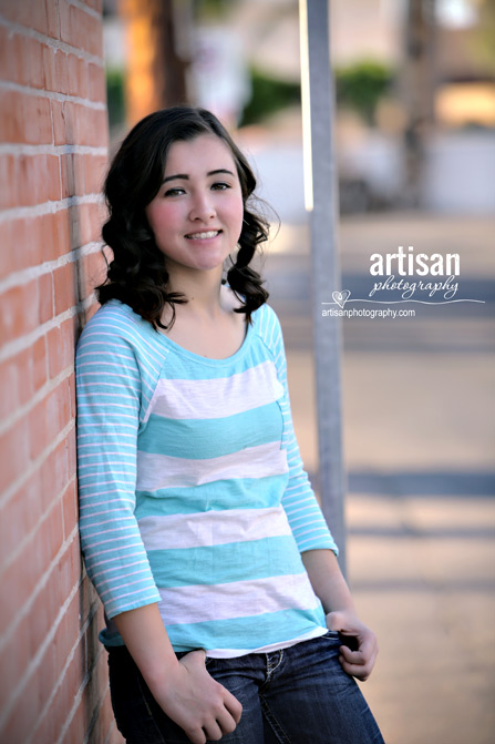 High School Senior photo of Girl  leannig against a brick wall