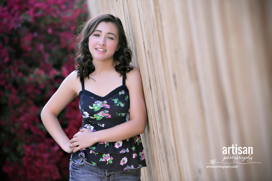 High School Senior photo of Girl leaning on wooden fence, prespective shot