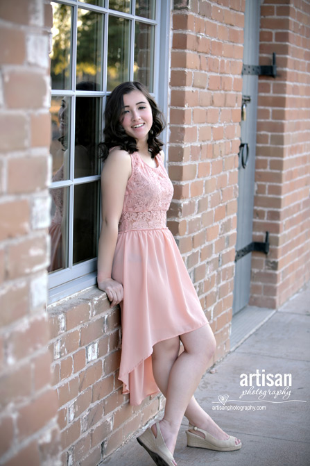 High School Senior photo of Girl leaning on brick wall