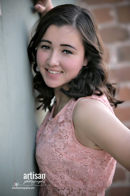 High School Senior photo of Girl on green wall with peach dress