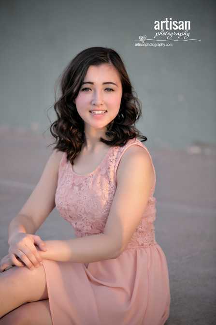 High School Senior photo of Girl on green wall with peach dress