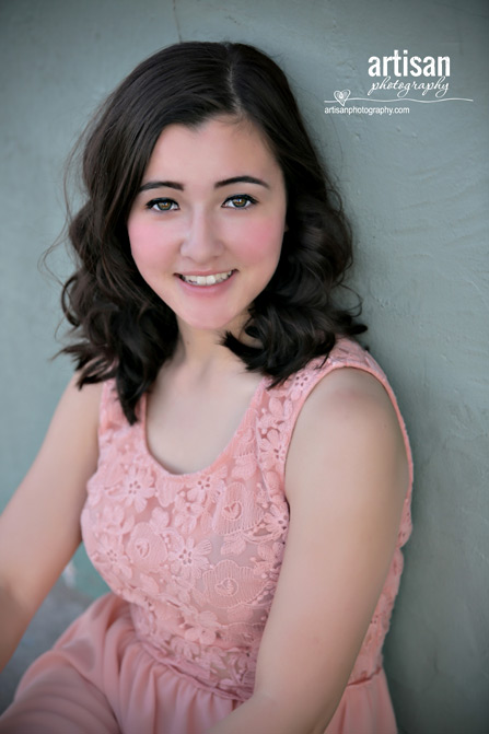 High School Senior photo of Girl on green wall with peach dress