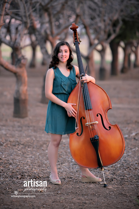 High School Senior photo of girl on a orchard with her music instrument