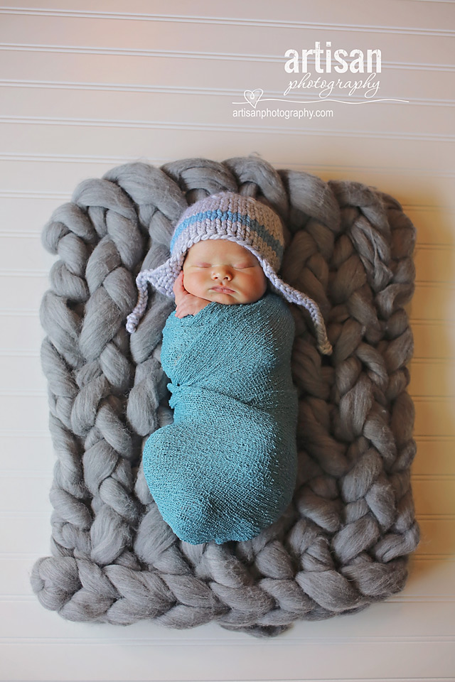 newborn baby boy photo laying on a grey chunky blanket in Carlsbad California