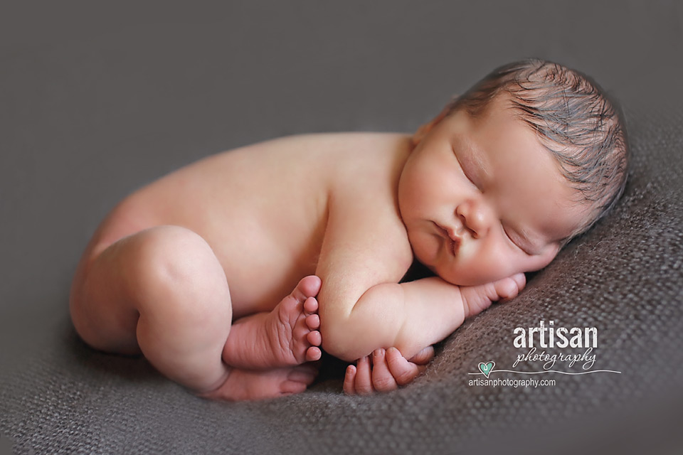 newborn baby boy laying on a grey blanket - taco pose- in Carlsbad california