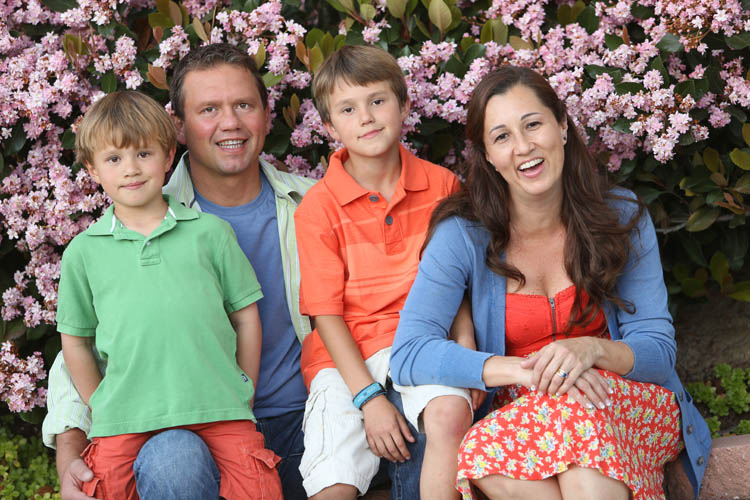 Family of 4 two adults and two young kids. In orange and blue