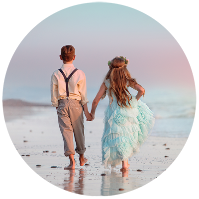 Siblings in fancy attire walking on the beach